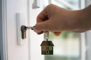 Hand holding house keys at front door in Baltimore