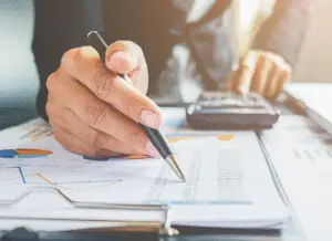 Tax professional reviewing financial documents with a pen and calculator, representing guidance on how to handle IRS notices and enforcement actions with confidence and clarity